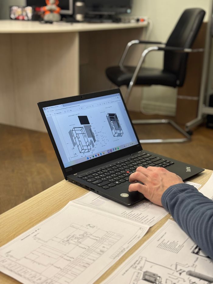 pexels photo 34938429 An engineer reviews detailed blueprints on a laptop at an office desk.